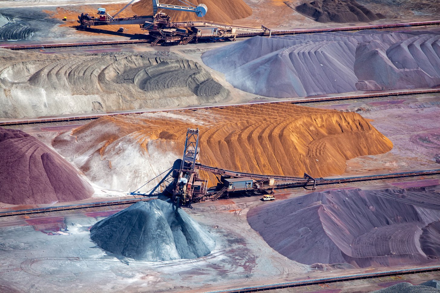 Aerial view of graded ore stockpiles and stacker-reclaimers at a bulk mineral terminal